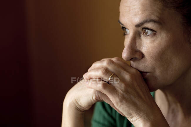 Задумчивая одинокая зрелая женщина смотрит на дом во время комендантского часа — стоковое фото