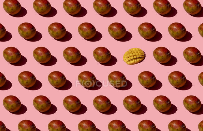 Whole and one chopped mango pattern on pink background — Stock Photo
