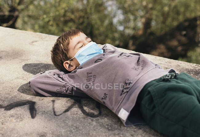 Портрет мальчика с закрытыми глазами в защитном релаксации на стене — стоковое фото