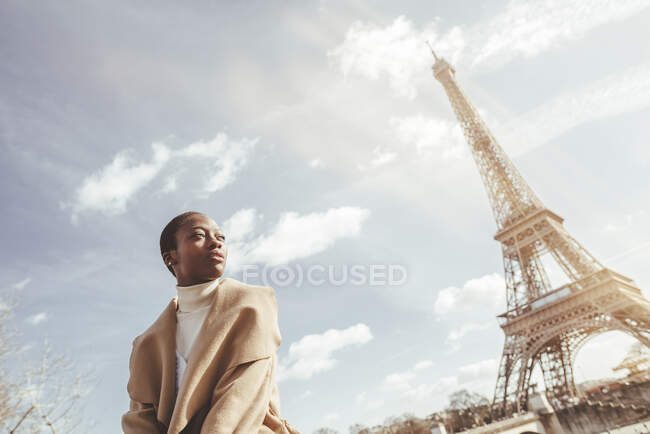 Jovem mulher atenciosa com Torre Eiffel no fundo durante o dia ensolarado, Paris, França — Fotografia de Stock
