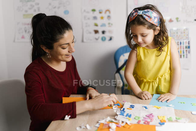 Madre e hija haciendo manualidades en casa - foto de stock