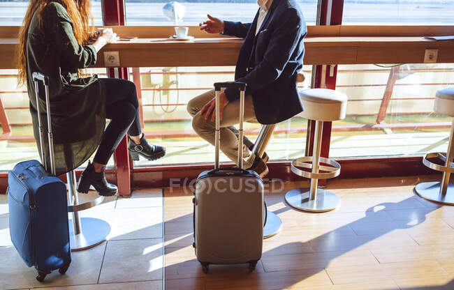 Casal de negócios sentado com bagagem no café do aeroporto — Fotografia de Stock