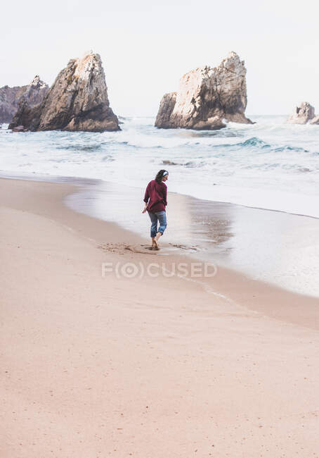 Mujer jugando en la orilla en Ursa Beach, Región de Lisboa, Portugal - foto de stock