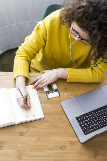 Donna che lavora alla scrivania in ufficio prendendo appunti — Foto stock