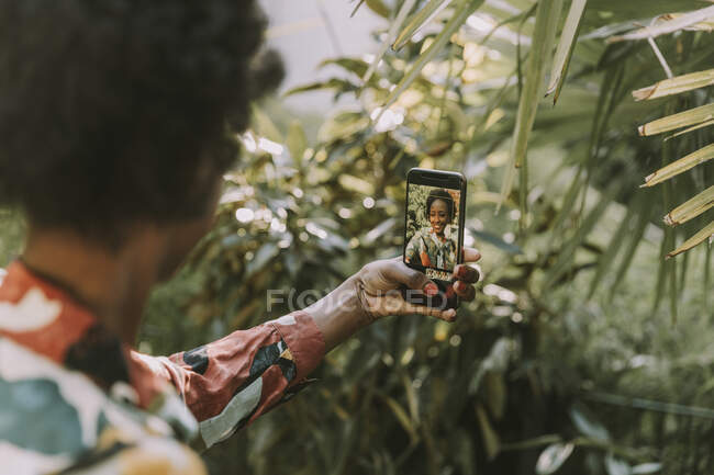 Giovane donna scattare selfie con smartphone in giardino — Foto stock