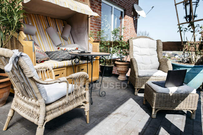 Terrazza con mobili da giardino e laptop — Foto stock