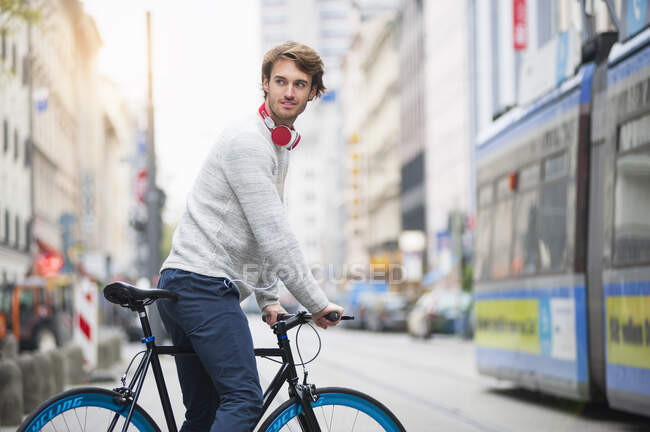 Портрет молодого чоловіка з велосипедом у місті. — стокове фото