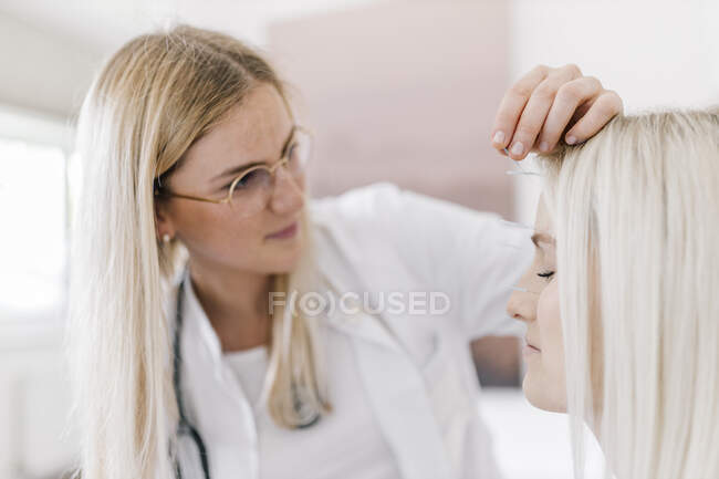 Agopuntura, giovane donna con ago da agopuntura durante il trattamento in faccia — Foto stock