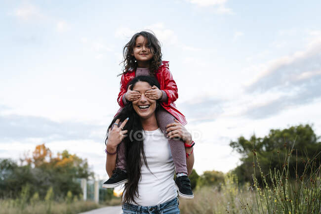 Madre con figlia sulle spalle, ragazza che si copre gli occhi — Foto stock