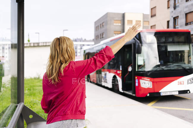 Femme arrêtant le bus à l'arrêt de bus — Photo de stock