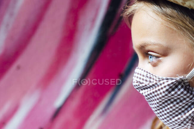 Close-up of girl with blue eyes wearing face mask while looking away — Stock Photo