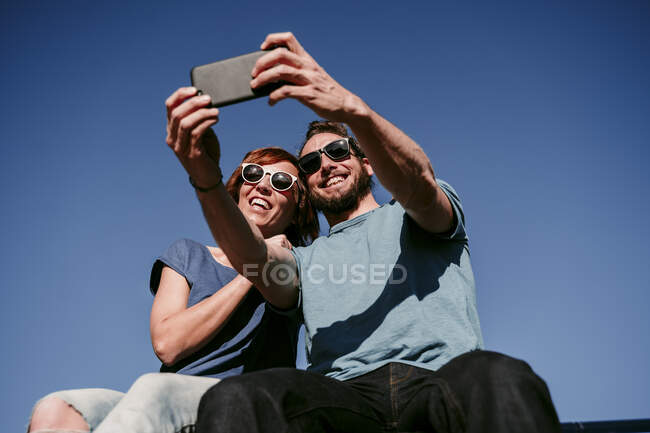 Happy couple taking a selfie under blue sky — Stock Photo