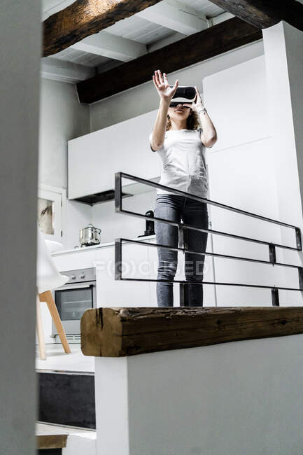 Mujer joven usando gafas de realidad virtual en casa - foto de stock