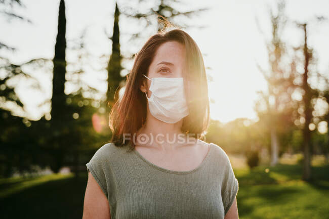 Portrait of pensive woman wearing protective mask in nature — Stock Photo