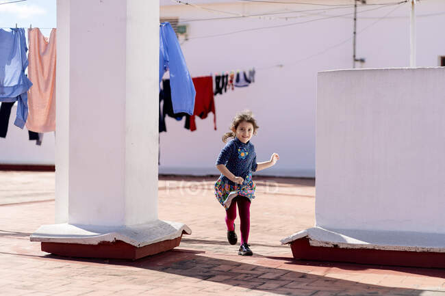 Porträt eines kleinen Mädchens, das auf dem Dach läuft — Stockfoto