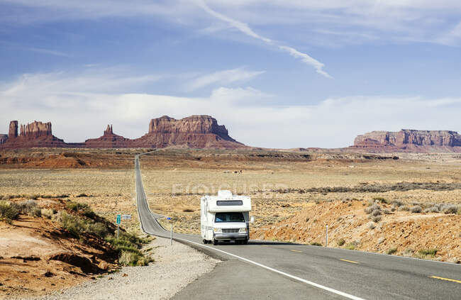 Motor home drives na estrada do deserto no Monument Valley Tribal Park contra o céu, Utah, EUA — Fotografia de Stock