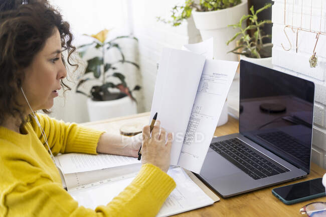 Femme travaillant au bureau à domicile examinant les documents — Photo de stock