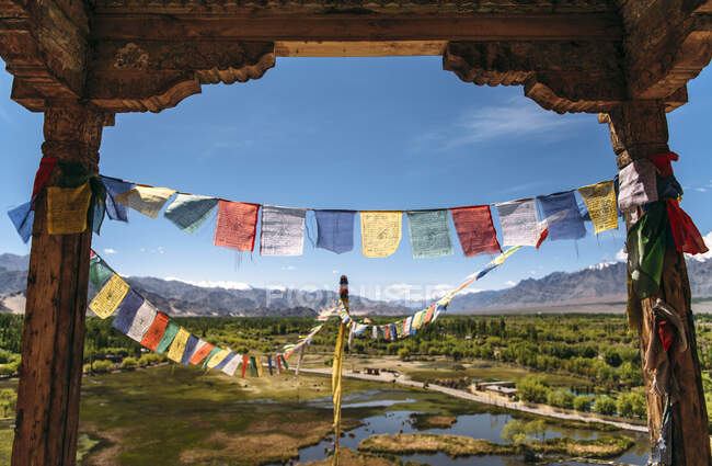 Inde, Ladakh, Drapeaux de prière colorés suspendus entre deux vieilles colonnes — Photo de stock
