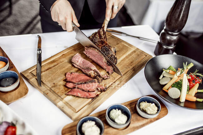 Hände des Chefs schneiden Tomahawk-Steak — Stockfoto