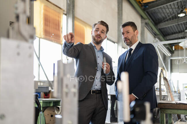 Two businessmen having a meeting in a factory — Stock Photo