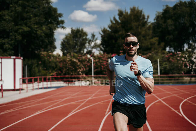 Männlicher Athlet läuft auf Tartanbahn — Stockfoto