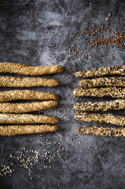 Studio shot of fresh Italian grissini breadsticks with sesame, flax and poppy seeds — Stock Photo