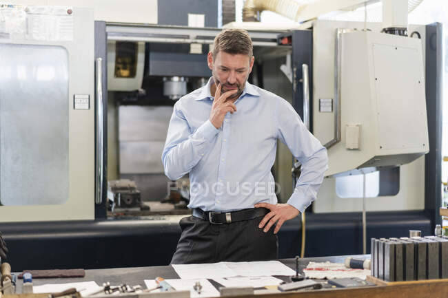 Reifer Mann schaut sich Plan in Fabrik an — Stockfoto