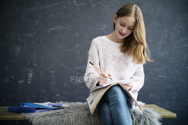 Fille apprentissage à la maison, écriture dans le cahier d'exercices — Photo de stock