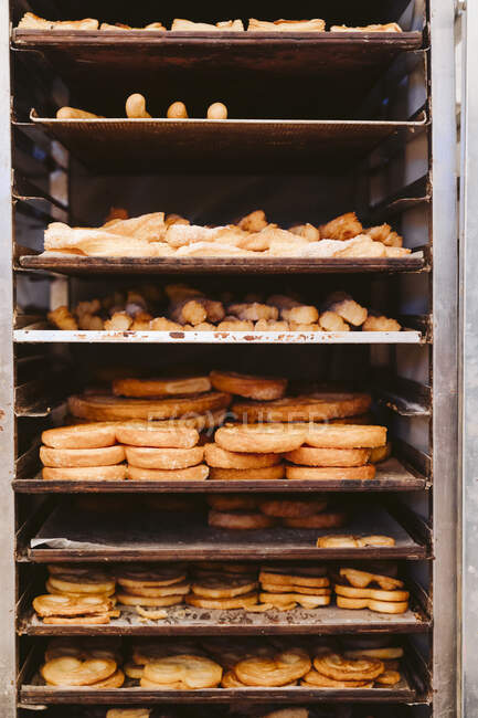 Various bread and cookies in shelves of trolley at bakery — Stock Photo