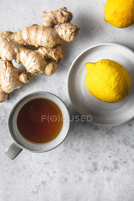 Plan studio de tasse de thé, citrons et racine de gingembre — Photo de stock