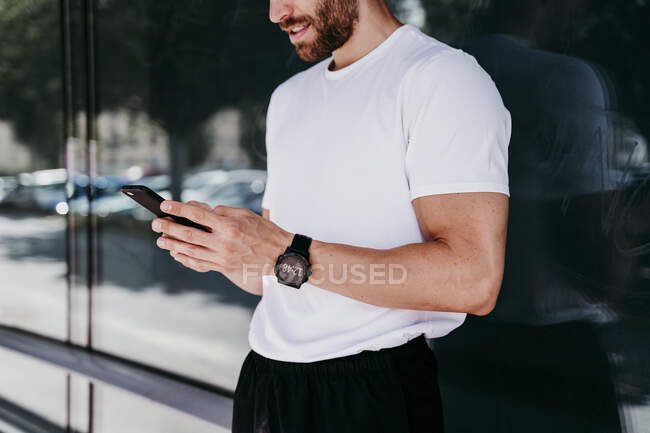 Männlicher Athlet macht Pause und checkt Smartphone — Stockfoto