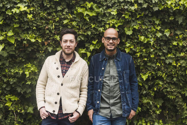 Gay coppia in piedi contro piante in parco — Foto stock