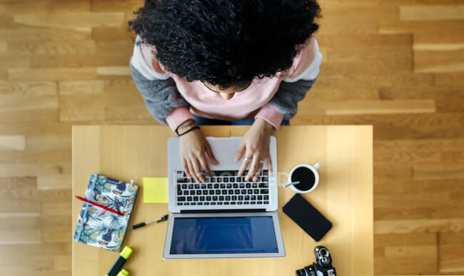 Top view of young woman working from home using laptop — Stock Photo