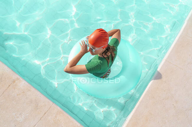 Donna con pneumatico galleggiante in piscina — Foto stock