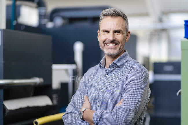 Portrait of a happy businessman in a factory — Stock Photo