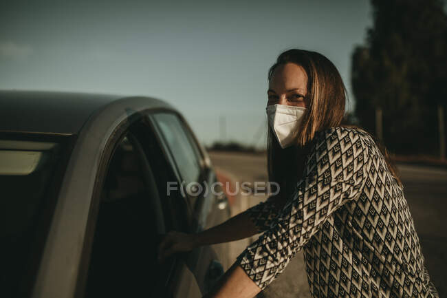 Mid adult woman with protective mask in car — Stock Photo