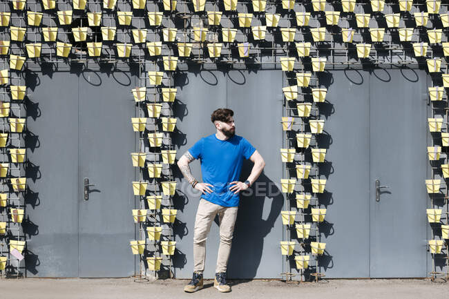 Молодий чоловік стоїть перед фасадом з трьома дверима — стокове фото