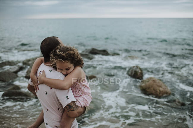 Père portant fille fatiguée à la plage — Photo de stock
