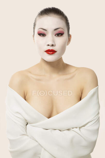 Jovem com maquiagem de ópera envolta em cobertor contra fundo branco — Fotografia de Stock