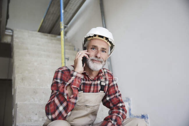 Construction worker phoning at construction site — Stock Photo