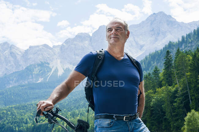 Homme âgé avec e-bike sur fond de nature — Photo de stock