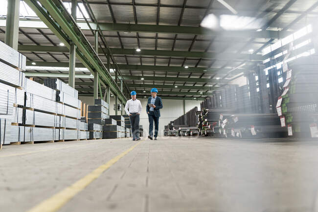 Dois empresários tendo uma reunião e andando em uma fábrica — Fotografia de Stock