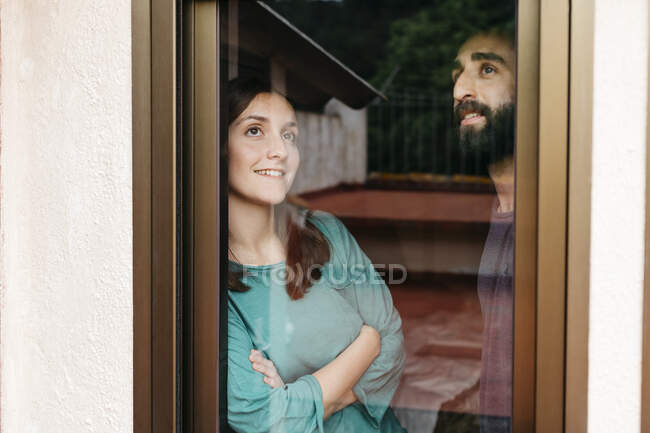 Coppia guardando fuori dalla finestra e pensando al futuro — Foto stock