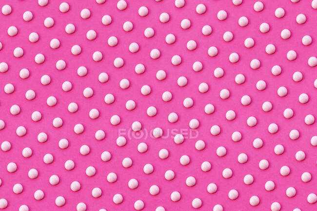 Patrón de gotas de líquido blanco sobre fondo rosa vibrante - foto de stock