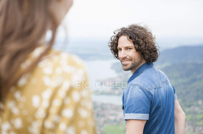 Усміхнений красивий чоловік дивиться назад на жінку — стокове фото