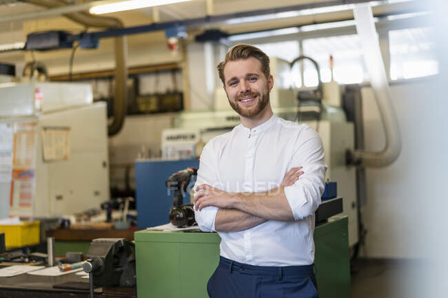 Portrait of a smiling young man in a factory — Stock Photo