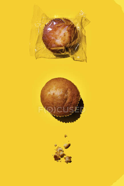 Estúdio tiro de dois muffins e migalhas em vez de um terceiro — Fotografia de Stock