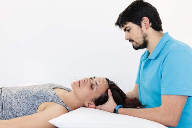 Visually impaired physical therapist massaging woman's head in clinic — Stock Photo