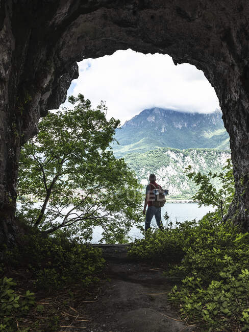 Explorador em pé na entrada da caverna — Fotografia de Stock
