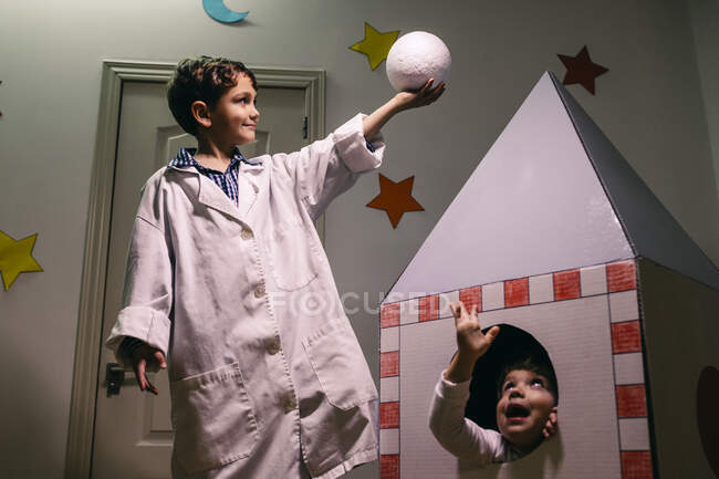 Siblings playing astronaut and researcher at home — Stock Photo